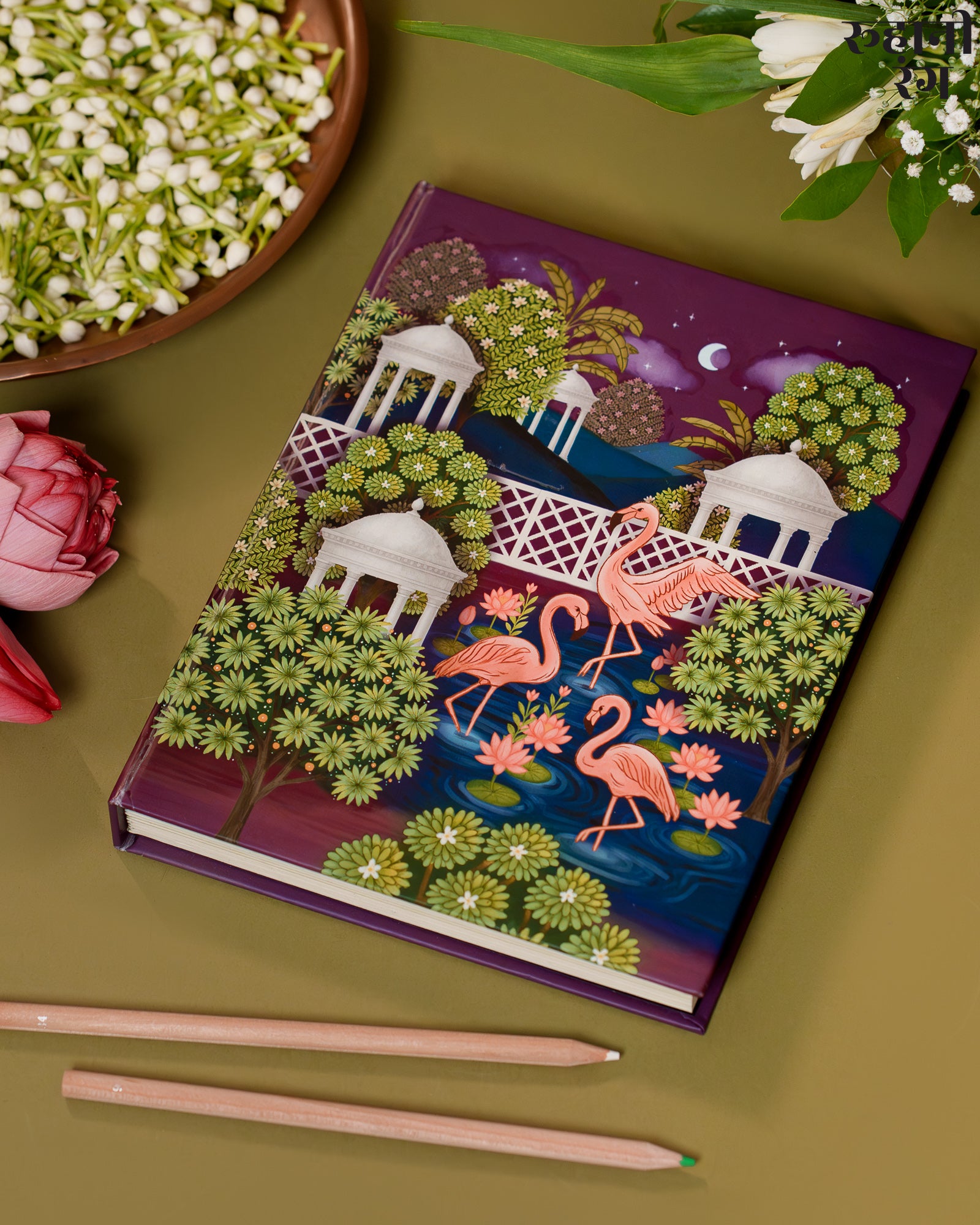 handmade 2026 planner with flamingo design on a green surface with flowers and pencils.