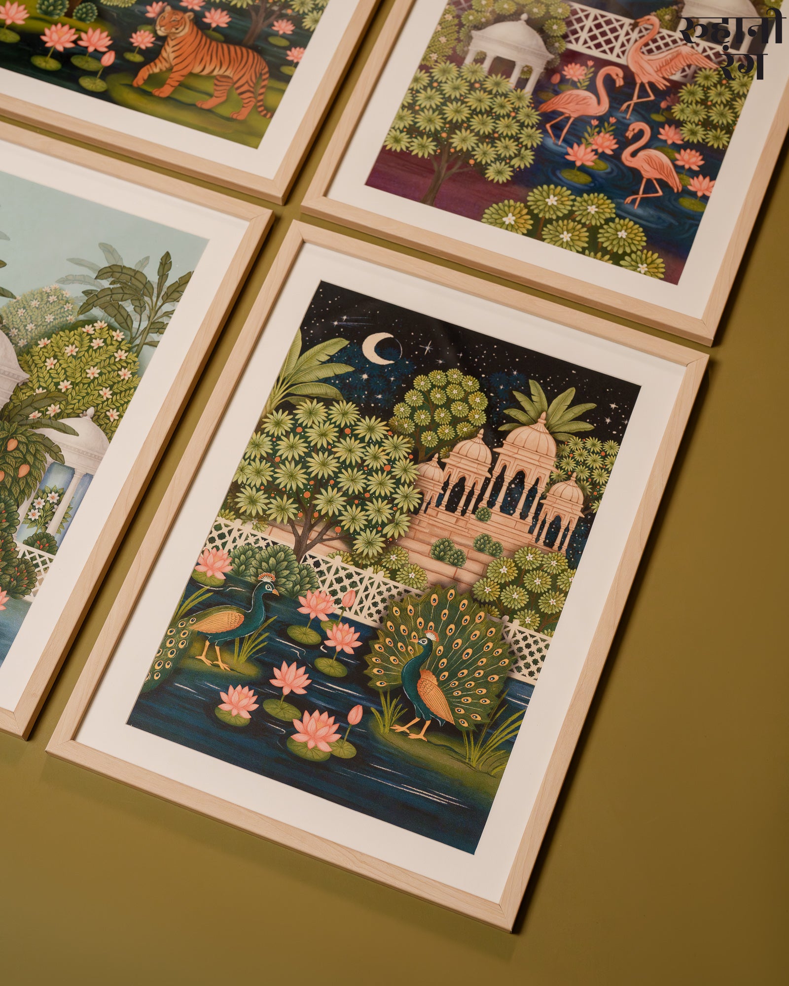 Framed illustrations of nature scenes on a wooden surface
