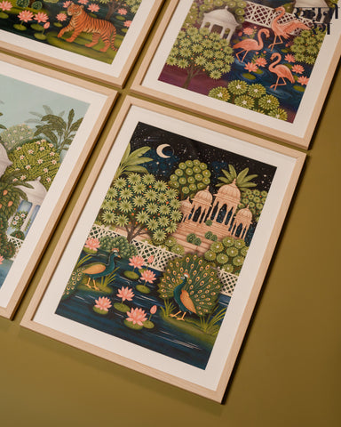 Framed illustrations of nature scenes on a wooden surface