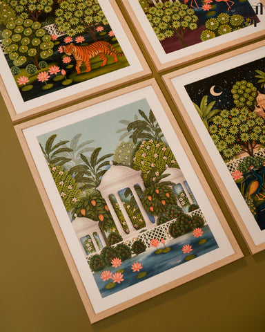 Set of four framed illustrations of nature scenes with animals on a brown surface.